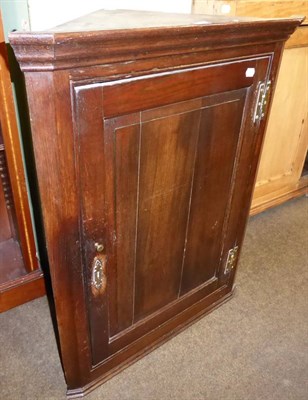 Lot 701 - A George III panelled oak hanging corner cupboard