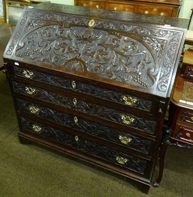 Lot 721 - A carved oak bureau