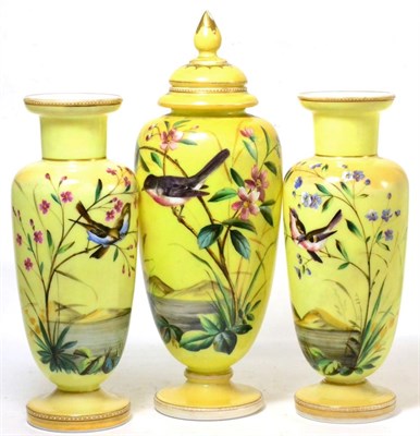 Lot 4 - A set of three Victorian yellow glass vases decorated with birds and flowers