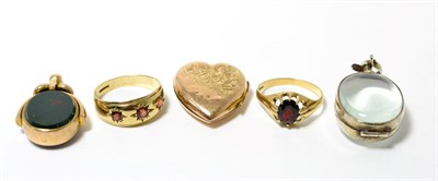 Lot 49 - A hardstone swivel fob, a crystal locket, a heart locket and two 9ct gold garnet rings (5)