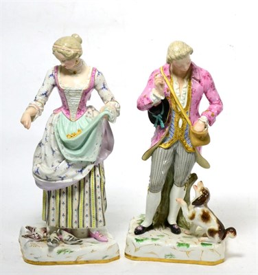 Lot 103 - A pair of porcelain figures of a man and dog and a woman feeding birds with faux blue cross...
