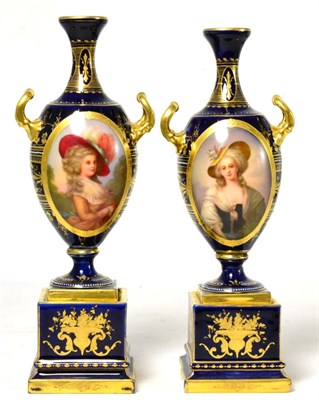 Lot 110 - A pair of Continental porcelain twin handled vases on stands, each painted with an oval...