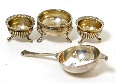 Lot 182 - A silver tea strainer of Art Deco style; a silver salt; and a pair of plated salts