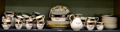 Lot 232 - A quantity of gilt highlighted floral painted cobalt blue and cream tea wares including...