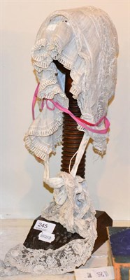 Lot 245 - Wig stand with lace bonnets