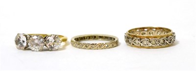 Lot 264 - An 18ct gold cubic zirconia three stone ring, an eternity ring and another eternity ring (3)