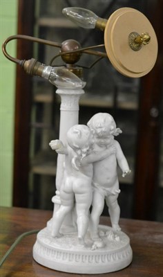 Lot 379 - A Parian figural table lamp decorated with putti