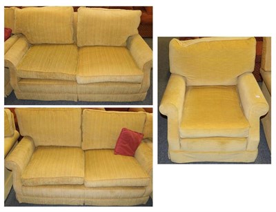 Lot 1169 - A pair of yellow upholstered sofas together with a similar armchair