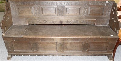 Lot 1172 - An early 19th century carved oak settle, dated 1816