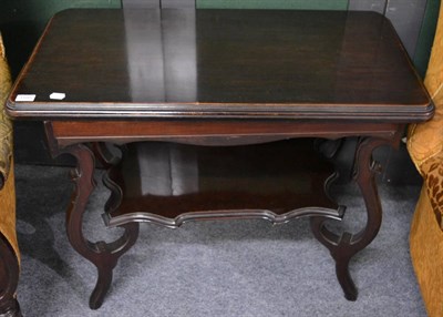 Lot 1185 - A mahogany fold over games table with shaped shelf structure