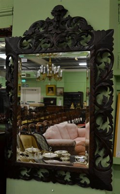 Lot 1230 - A carved oak mirror with bevelled rectangular mirror plate