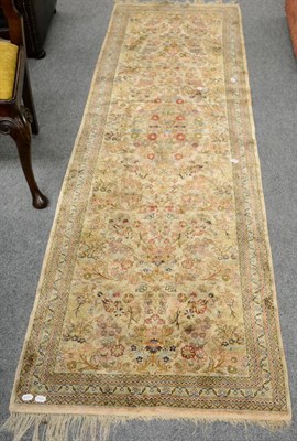 Lot 1321 - Narrow silk runner, China, the ivory field with a floral medallion framed by narrow borders,...