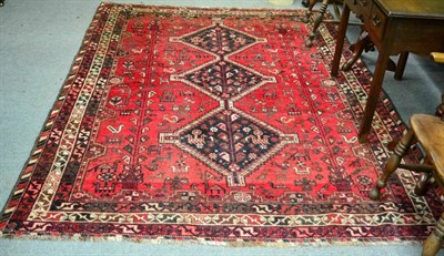 Lot 1324 - Kashgai rug, south west Iran, the raspberry field with three diamond medallions enclosed by...