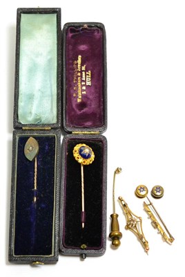 Lot 253 - Two diamond set stickpins, an enamel stickpin, two diamond set studs and two brooches