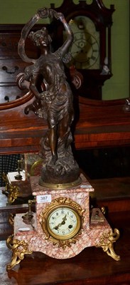 Lot 387 - A French figural striking mantel clock, the rouge marble base surmounted by a spelter Classical...