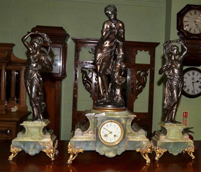 Lot 393 - A green onyx and spelter figural striking mantel clock with garniture in the French taste