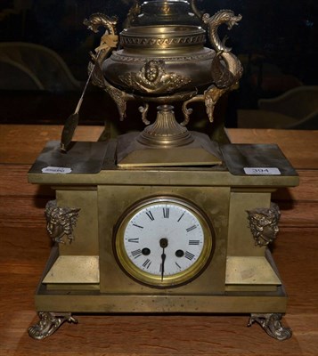 Lot 394 - A brass striking mantel clock in the Classical taste, the body decorated with masks and raised...