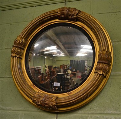 Lot 536 - A Regency circular gilt wood convex mirror with ebonised slip