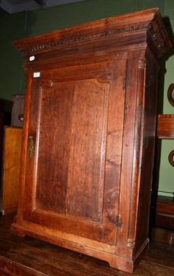 Lot 551 - A George III panelled oak hanging corner cupboard opening to reveal recesses and drawers