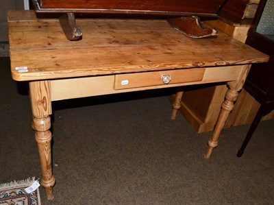 Lot 554 - A pine farmhouse kitchen table with a drop leaf and fitted with a drawer