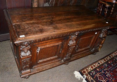 Lot 588 - A carved oak low two door cupboard