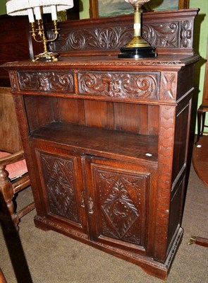 Lot 590 - A Victorian carved oak cabinet with two drawers over a recess above a pair of cupboard doors