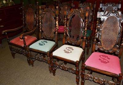 Lot 614 - A set of ten carved oak chairs with bergere backs and needlework seats bearing an 'S' monogram...