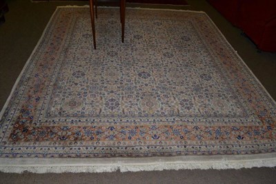 Lot 616 - An Indian carpet of unusual size, the ivory field with rows of stylised flowerheads enclosed by...