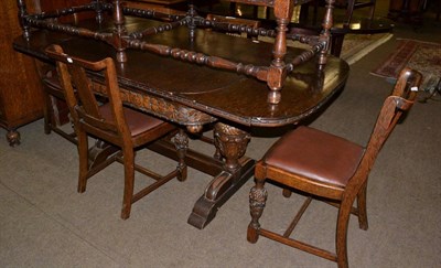 Lot 635 - Carved oak extending dining table together with four chairs