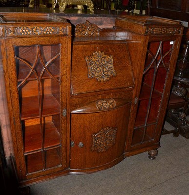 Lot 636 - A carved oak bureau, the fall front flanked by twin glazed doors