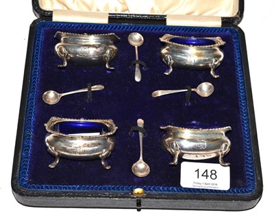 Lot 148 - A cased set of four silver salts with spoons and blue glass liners
