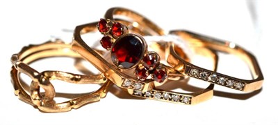 Lot 248 - A garnet ring, a set of three rings and a bamboo link ring (5)