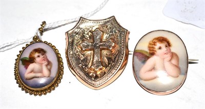 Lot 402 - A cross motif brooch and two Cupid decorated pieces