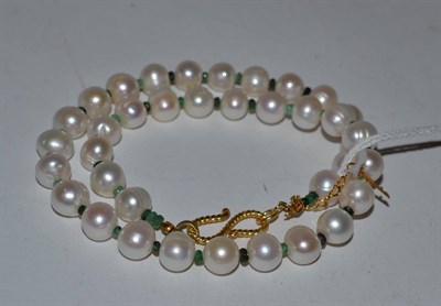 Lot 429 - A cultured pearl and emerald necklace, the oval cultured pearls alternate with faceted...