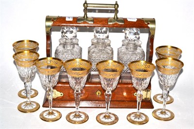 Lot 437 - A three bottle brass mounted oak tantalus together with a set of eight gilt highlighted cut...