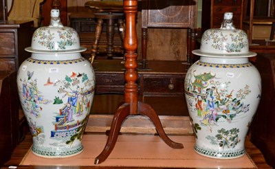 Lot 489 - A pair of Chinese porcelain jars and covers decorated with figures and each with fo dog knop