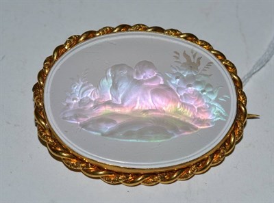 Lot 519 - A Victorian reverse engraved glass brooch with mother of pearl reflector and yellow mount