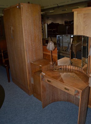 Lot 1078 - A 1930's/1940's oak bedroom suite comprising of a wardrobe, dressing table and bedside cabinet