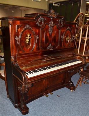 Lot 1101 - A Victorian rosewood upright piano, ornately carved, with twin sconces