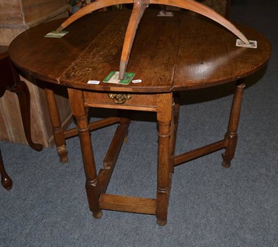 Lot 1107 - An oak gateleg dining table