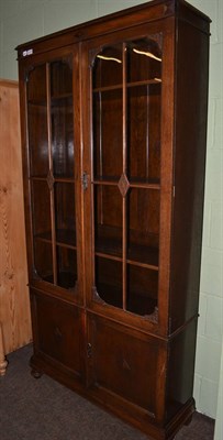 Lot 1249 - A tall oak bookcase/cabinet