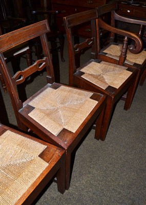 Lot 1312 - A set of four country oak dining chairs with rope work drop in seats, including one carver