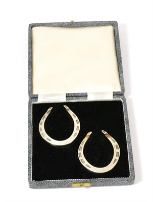 Lot 95 - A pair of silver horseshoe napkin rings