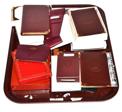 Lot 47 - A collection of leather Dupont and Cartier wallets, purses, address books, luggage tags, watch...