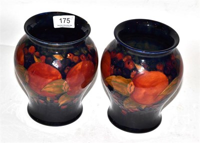 Lot 175 - A pair of William Moorcroft Pomegranate pattern vases, on blue grounds, green painted...