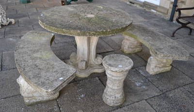 Lot 369 - A composition garden table, benches and stools