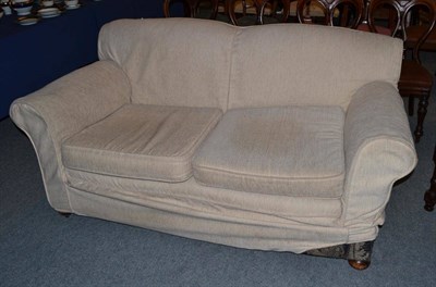 Lot 490 - A cream two seater sofa