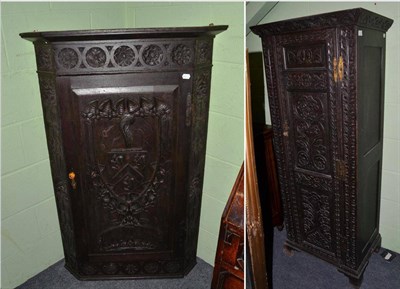 Lot 533 - An 18th century carved oak corner cupboard, decorated with a coat of arms, together with an...