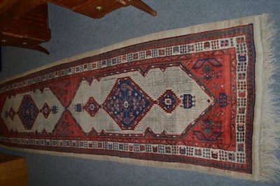 Lot 545 - Narrow Sarab Runner, Persian Azerbaijan, the madder field with two lozenge medallions framed by...