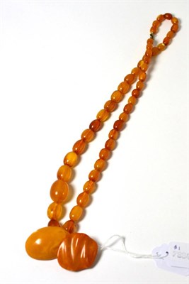 Lot 48 - An amber forty seven bead necklace and two amber brooches (3)